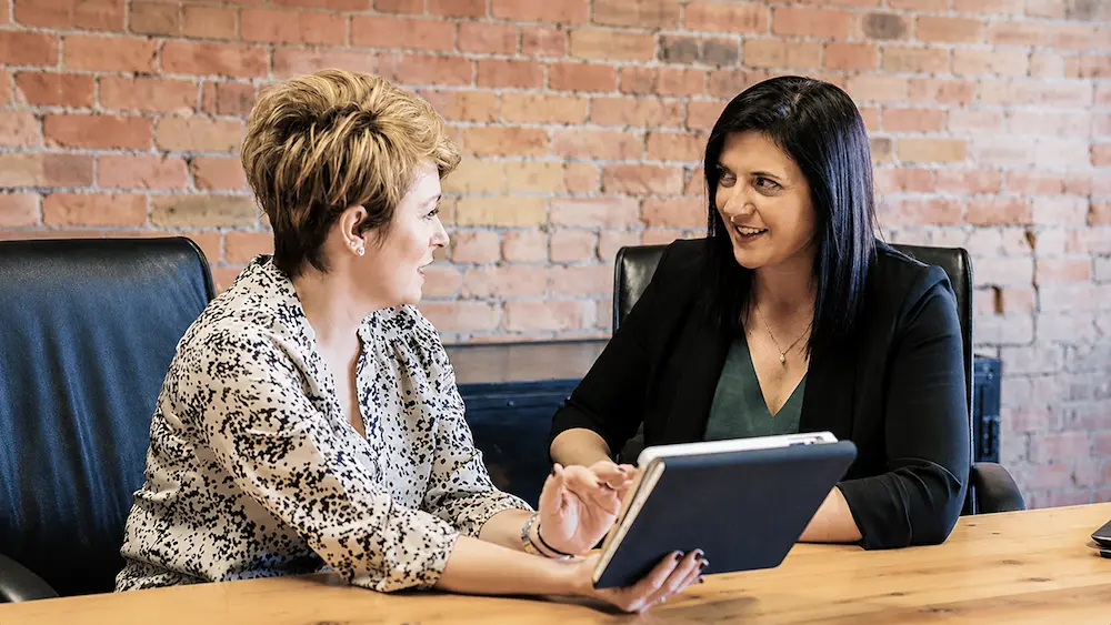 Two professionals having a discussion at a conference table
